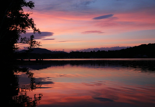 First light breaks on an Autumn sunrise over Lake Flower, Saranac Lake, Adirondack Mountains High Peaks Region.