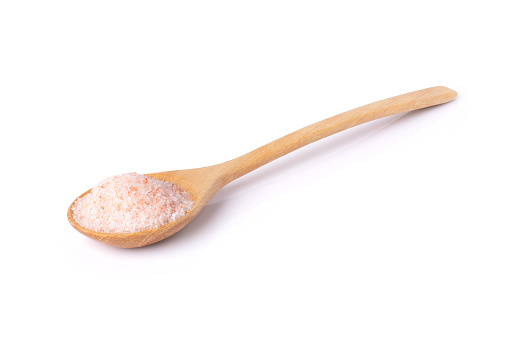 Pink himalayan salt in wooden spoon isolated on white background