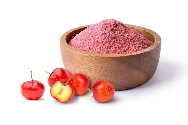 Acerola cherry powder in wooden bowl with fresh fruits isolated on white background.