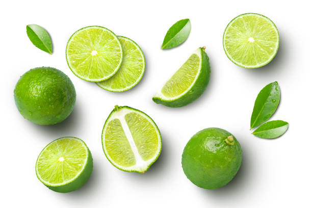 frutos de lima con hoja verde y cortados por la mitad en rodaja aislados sobre fondo blanco. - limones verdes fotografías e imágenes de stock