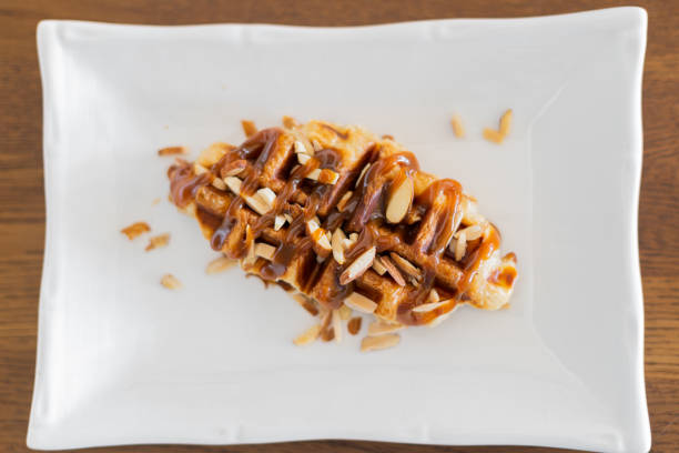 Caramel croffle and sprinkled with almonds in white plate