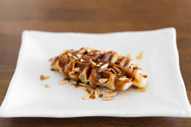 Caramel croffle and sprinkled with almonds in white plate