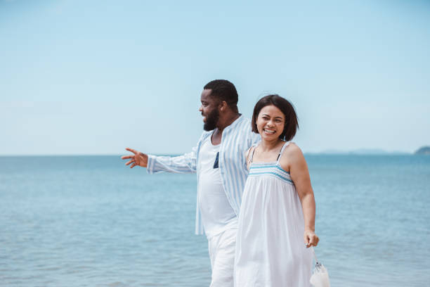 istock Romantic American African couple walking together while on the beach 1401271715