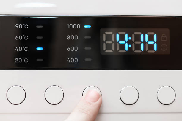 istock Washing machine display close up ,time remaining four hour 14 minutes during washing process. Finger selects wash mode. Abstract laundry programming backdrop 1401272273