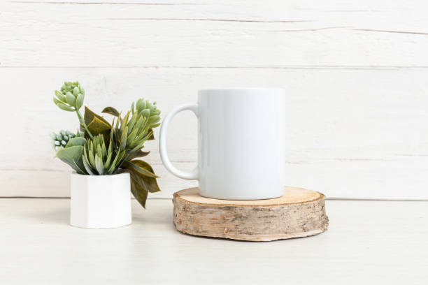 istock White ceramic mug on the table with a pot of flowers. 1401277209