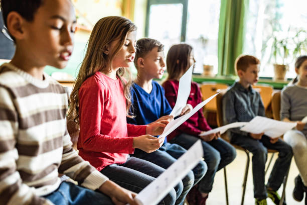 schulkinder üben mit noten auf einer klasse in der schule. - sheet music music classroom education stock-fotos und bilder