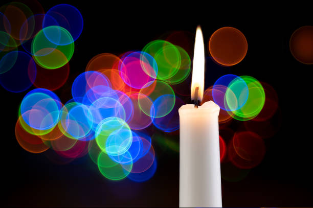 festive candle on a black background with colorful lights