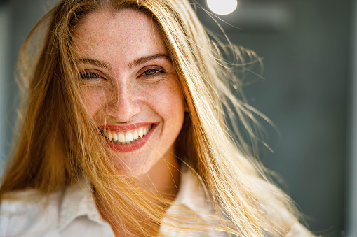 Portrait of a happy redhead woman looking at camera.