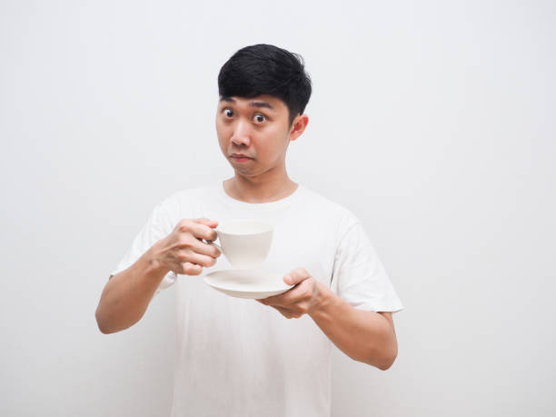 istock Asian man holding coffee cup invite to taste face white background 1401282005