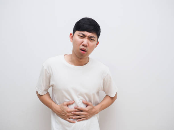 istock Man stomach ache touch his belly unhappy face on white background 1401282012