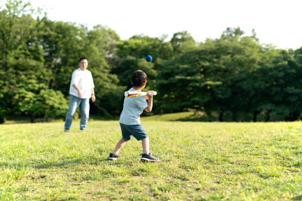 vater und sohn spielen baseball - baseball hitting baseball player child stock-fotos und bilder