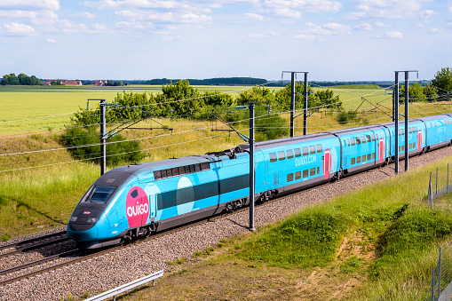 Champdeuil, France - June 1, 2022: A TGV Duplex Ouigo high speed train from french rail company SNCF is driving to Paris on the LGV Sud-Est in the countryside.