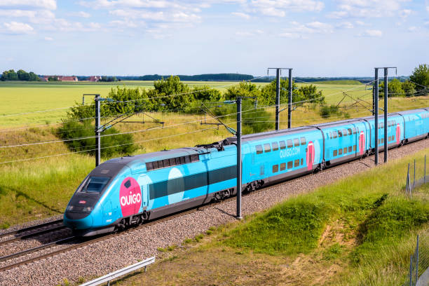 A TGV Ouigo high speed train in the countryside. Champdeuil, France - June 1, 2022: A TGV Duplex Ouigo high speed train from french rail company SNCF is driving to Paris on the LGV Sud-Est in the countryside. electric train photos stock pictures, royalty-free photos & images