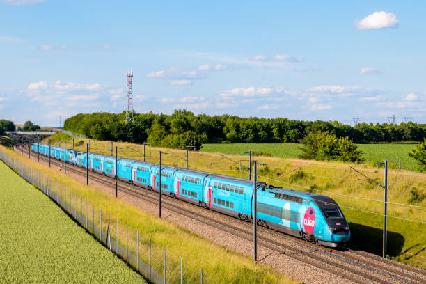 A TGV Ouigo high speed train in the countryside. Champdeuil, France - June 1, 2022: A TGV Duplex Ouigo high speed train from french rail company SNCF is driving from Paris on the LGV Sud-Est in the countryside. duplex photos stock pictures, royalty-free photos & images