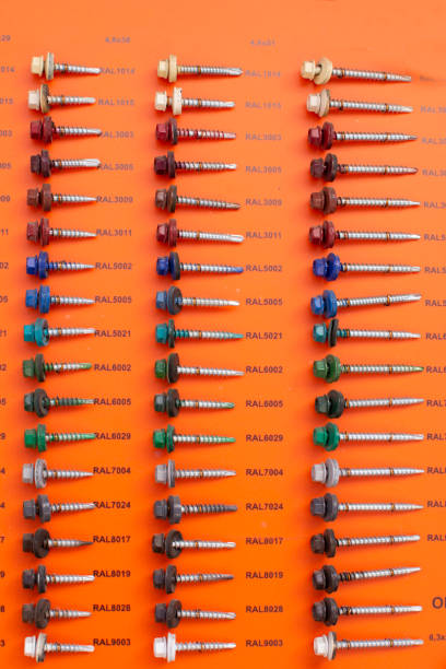 bolts of different lengths and diameters on an orange background. Building materials
