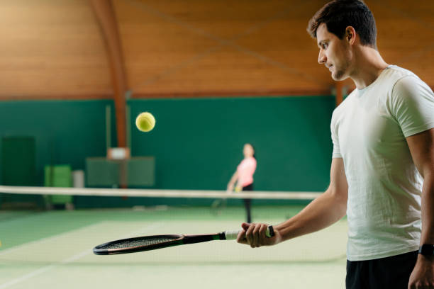 istock Young male instructor in tennis uniform balancing ball on racket 1401285575
