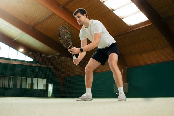 istock Young male instructor holding racquet and standing in ready position 1401286323