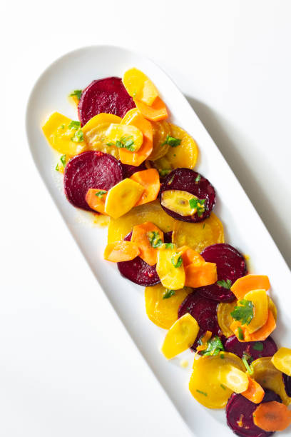 red, orange, yellow sliced beet and carrot ssalad - golden beet fotos imagens e fotografias de stock