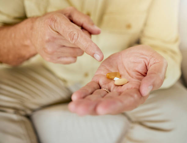 istock An unknown man showing his pills while sitting at home. Unrecognizable mature man taking his daily treatment for chronic disease and illness 1401289335