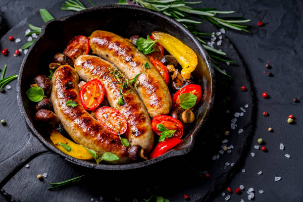 istock Grilled sausages and vegetables with herbs in iron pan 1401289679