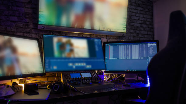 Video footage on computer screens with controls at desk stock photo
