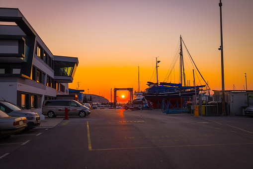 Modern office building with parked cars at commercial dock during sunset