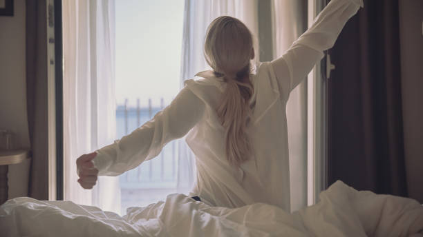 istock Woman stretching hands on bed after wake up in hotel 1401298317