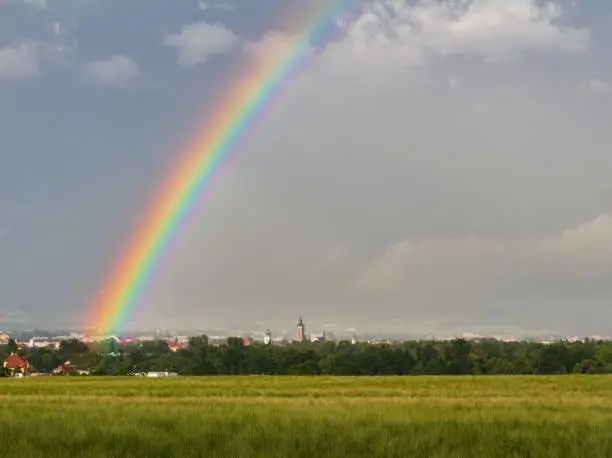 City Ceske Budejovice with storm cloud sky, rainbow and barley filed. Czech republic