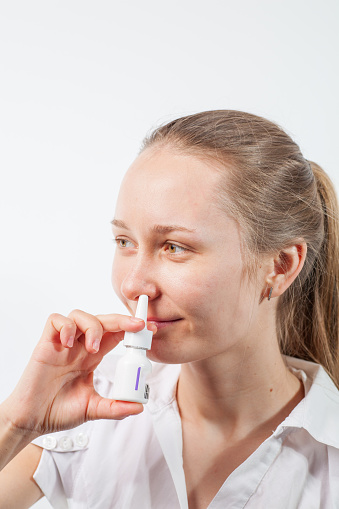 The girl drips nose drops from a runny nose with influenza