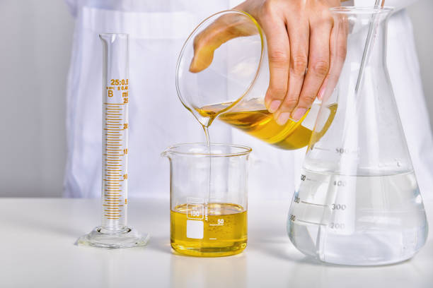 Oil pouring, Laboratory and science experiments, Formulating the chemical for medical research, Quality control of petroleum industry products concept. Oil pouring, Laboratory and science experiments, Formulating the chemical for medical research, Quality control of petroleum industry products concept. beaker pour stock pictures, royalty-free photos & images
