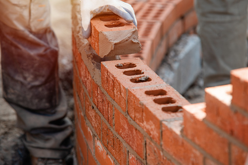 Stack of red bricks on construction site.