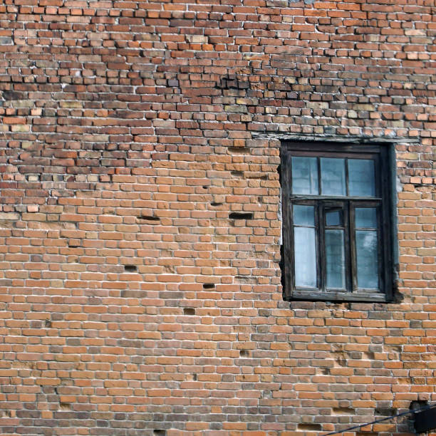 istock Abandoned old window in a dirty red brick wall 1401303215