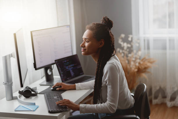 istock Side view of mixed-race young professional concentrated skilled web expert working on computer 1401307581