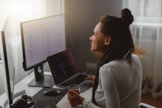 istock Close up of happy young mixed-race female IT worker smiling coding on computer at home 1401307609