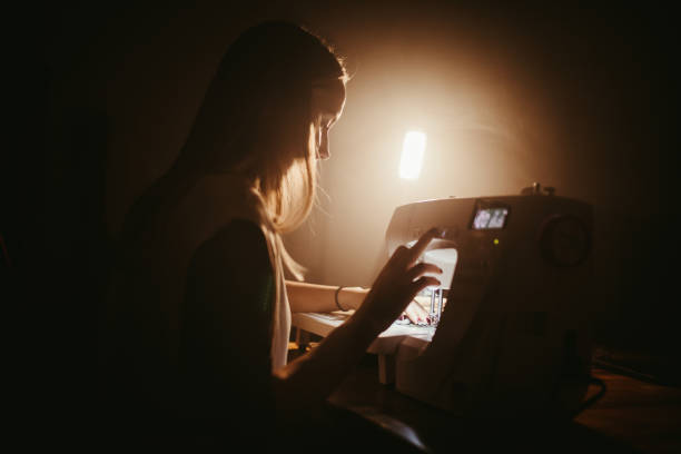 istock Young fashion designer stitching clothes at night 1401307870