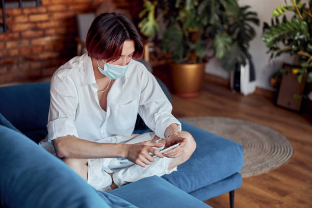 istock Asian man in protective face mask watching the smartphone at home 1401309404
