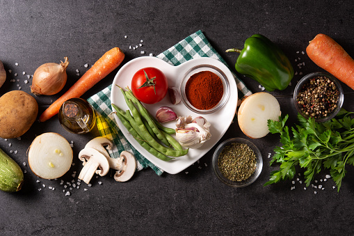 Assortment of vegetables, herbs and spices on black background