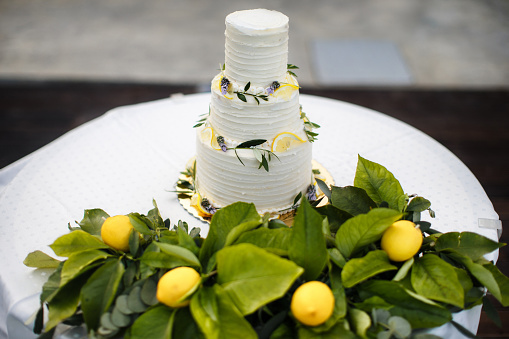 Beautiful wedding cake decorated with yellow lemons.