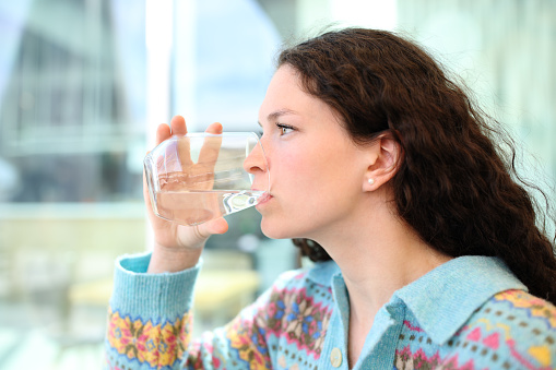 Woman drinking water from glass in a bar terrace