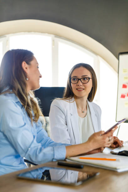 istock Two businesswomen discussing ideas when co-working on a project 1401313026