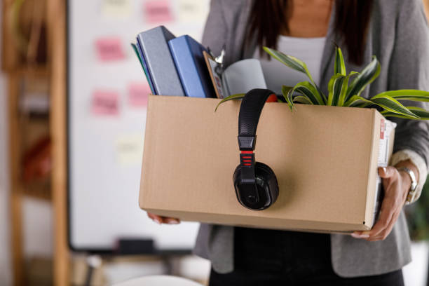 businesswoman holding a cardboard box with personal belongings - firing unemployment downsizing box imagens e fotografias de stock