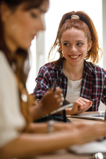 istock Joyful female entrepreneur brainstorming ideas with a colleague while working on a creative project 1401315223
