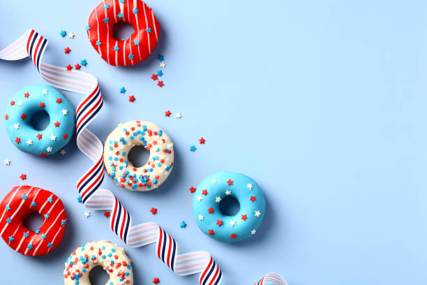 joyeux quatrième de juillet, jour de l’indépendance des états-unis. modèle de carte de vœux du 4 juillet avec des beignets aux couleurs du drapeau américain et un ruban rayé sur fond bleu. - flag glass striped fourth of july photos et images de collection