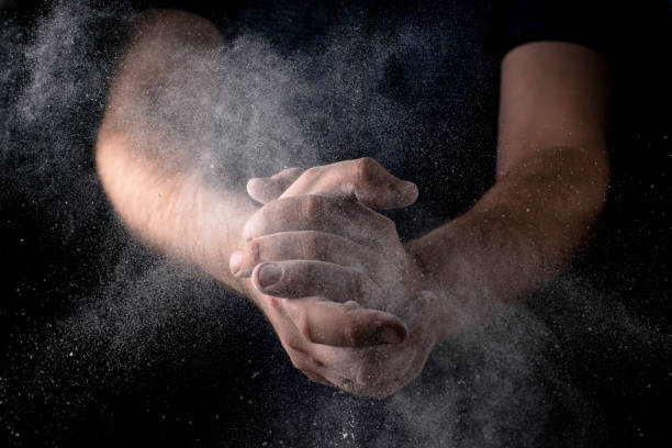 istock A man claps his hands with scattering flour against a dark background. Culinary theme. 1401317756