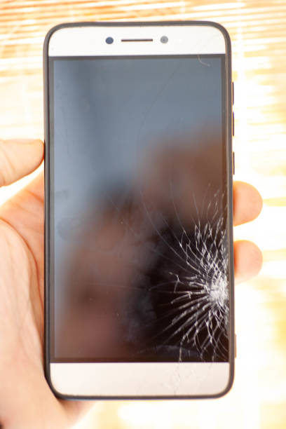 istock Broken glass of smart phone on the wood table. Selective focus. 1401319883