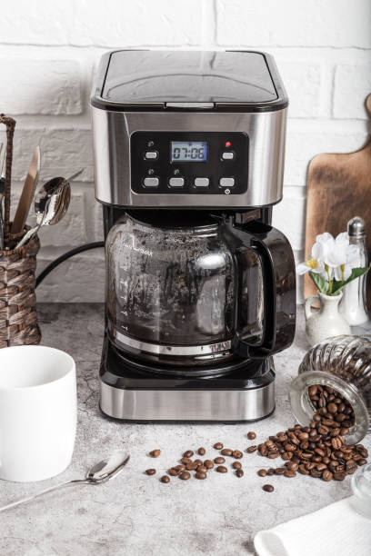 istock Drip coffee maker and white cup. Preparing hot coffee in a coffee machine. Household appliances on the kitchen table 1401323142