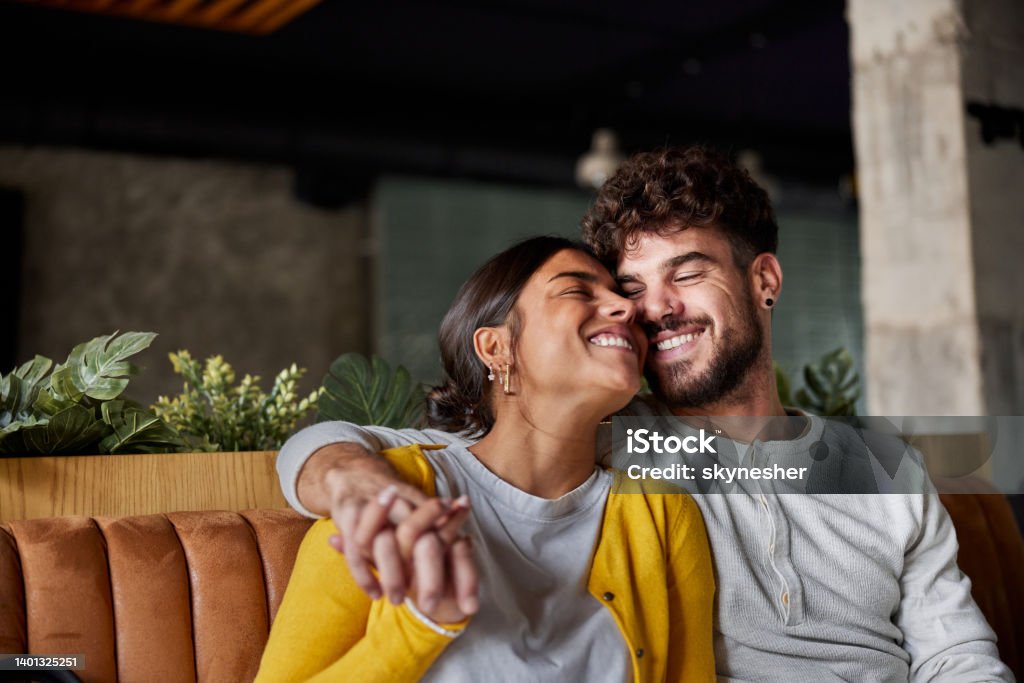 Happy couple embracing with great affection. Young loving couple embracing while spending their time together. Couple - Relationship Stock Photo