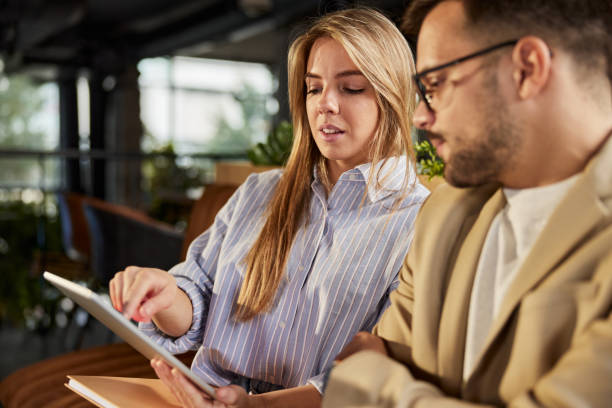 istock Young business couple working on digital tablet. 1401325379