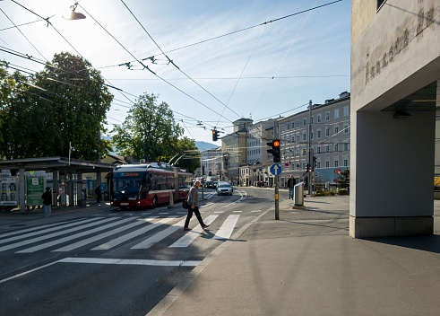 Trams on Rudolfskai in Salzburg, Austria. In the foreground are the electrified cables for the trolley buses.