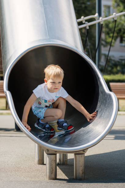 istock Boy sliding down the slide on the playground. 1401328435